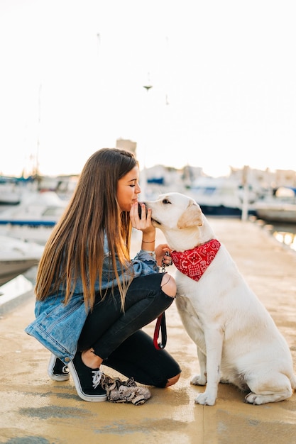 Frau mit Hund im Hafen bei Sonnenuntergang