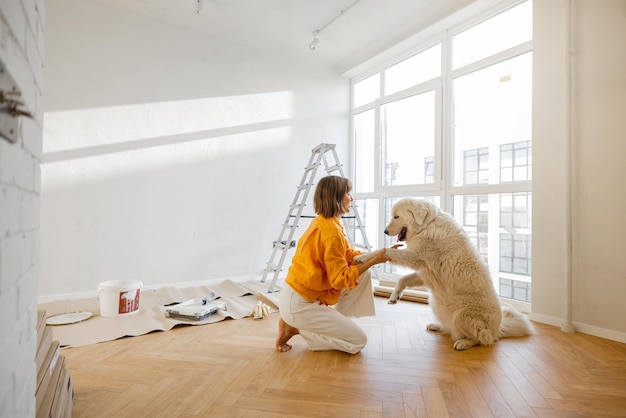 Frau mit Hund im Zimmer bei der Reparatur in der Wohnung