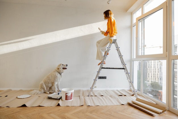 Frau mit Hund renoviert Haus