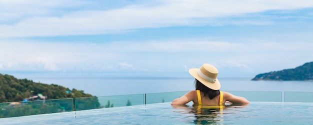 Frau mit Hut, der in einem Pool entspannt