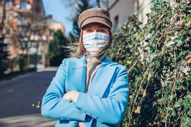 Frau mit Hut, die Maske im Freien trägt