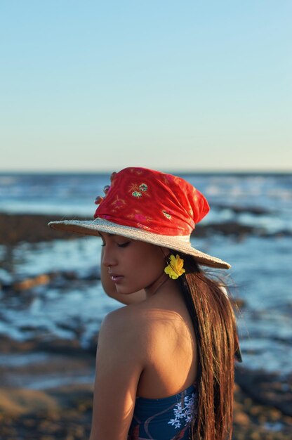 Frau mit Hut gegen das Meer gegen den klaren Himmel