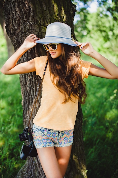 Frau mit Hut mit einem Baum Hintergrund