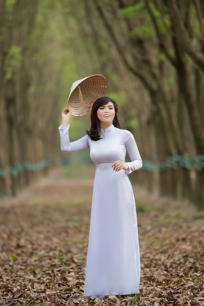 Frau mit Hut steht auf dem Feld