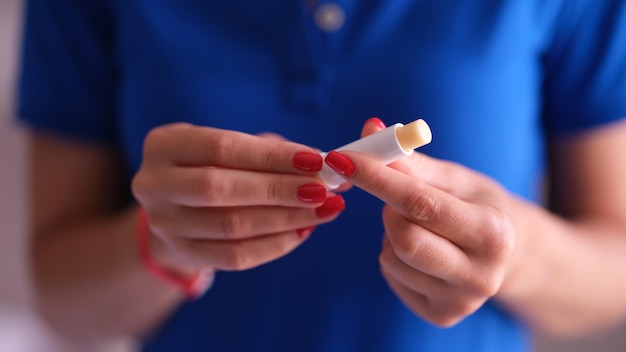 Frau mit hygienischem Lippenstift in der Hand Nahaufnahme