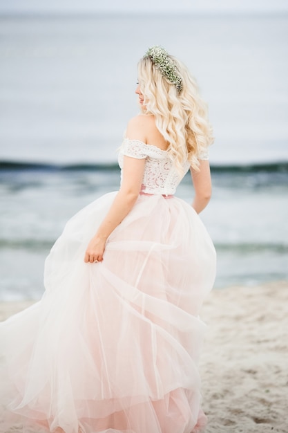 Frau mit ihrem Brautkleid auf das Meer