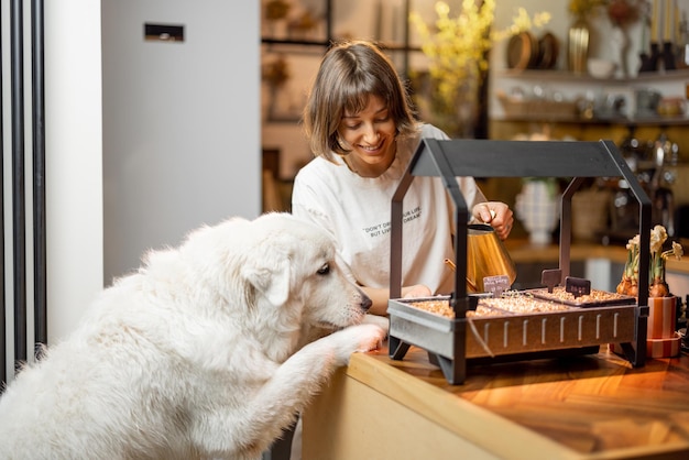 Frau mit ihrem Hund, der zu Hause Gemüse anbaut