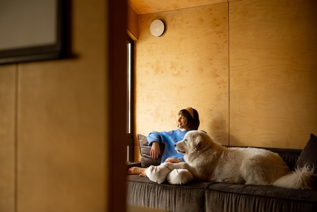 Frau mit ihrem Hund im Holzhaus in der Natur