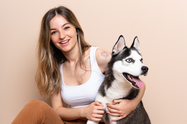 Frau mit ihrem Husky, der auf Boden sitzt