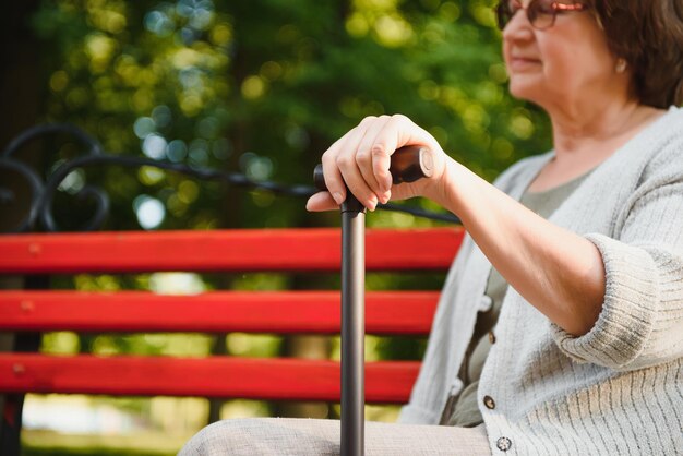 Frau mit ihrem Spazierstock im Park