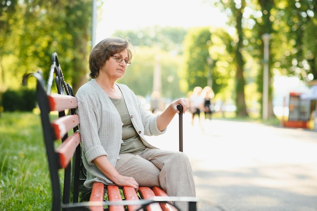 Frau mit ihrem Spazierstock im Park