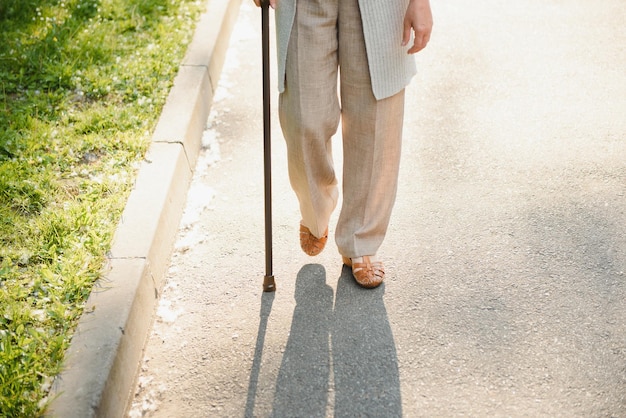 Frau mit ihrem Spazierstock im Park