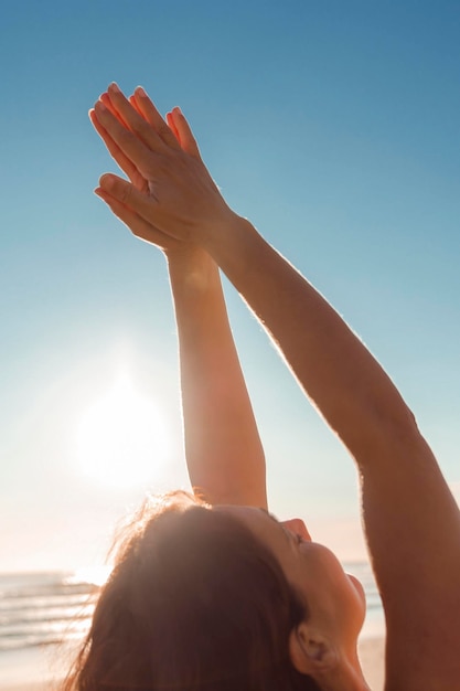 Frau mit ihren zum Himmel erhobenen Händen in einer Position des Dankes