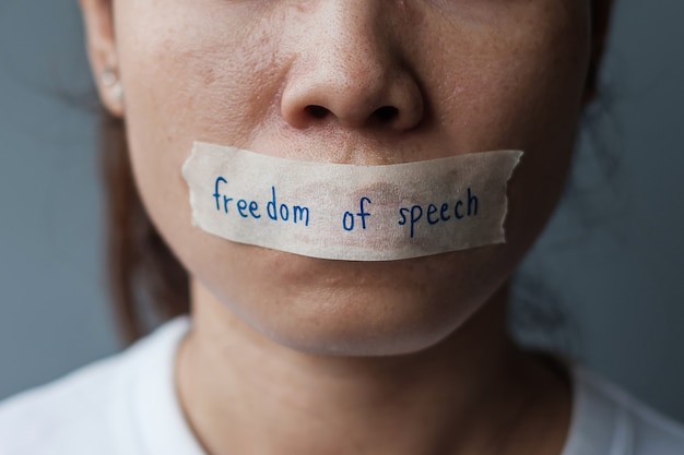 Frau mit in Klebeband versiegeltem Mund mit Botschaft zur Redefreiheit., Pressefreiheit, Menschenrechte, Protestdiktatur, Demokratie, Freiheit, Gleichheit und Brüderlichkeitskonzepte