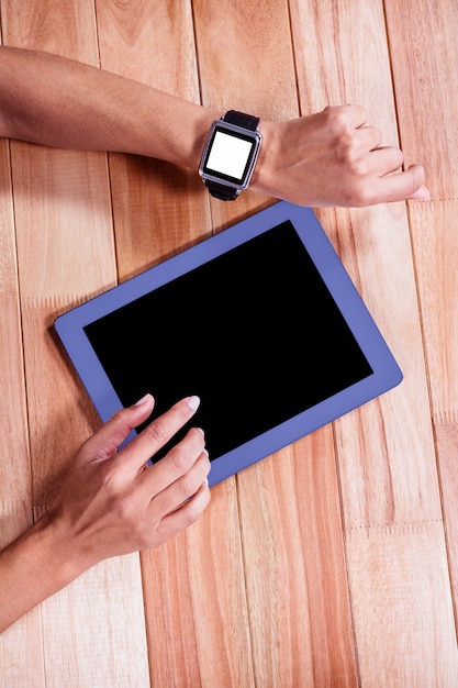 Frau mit intelligenter Uhr und digitaler Tablette