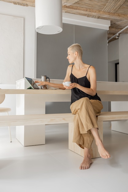 Frau mit Kaffee in moderner Wohnung