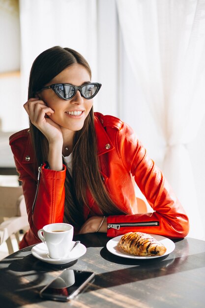 Frau mit Kaffee und Croissant