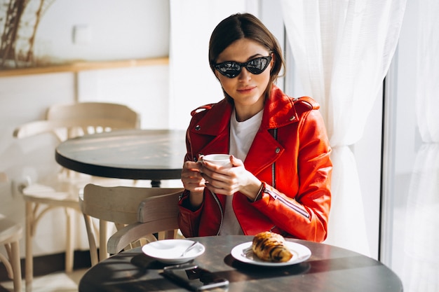 Frau mit Kaffee und Croissant