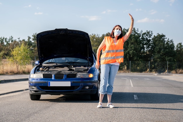 Frau mit kaputtem Auto, das versucht, Hilfe zu bekommen