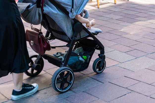 Frau mit Kinderwagen geht in der Stadt spazieren