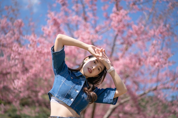 Frau mit Kirschblüten oder Sakura-Blume, die im Park blüht