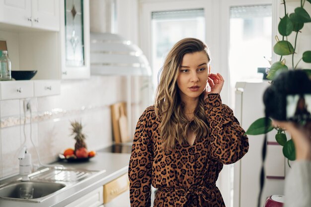 Frau mit Kleid mit Leopardenmuster posiert zu Hause