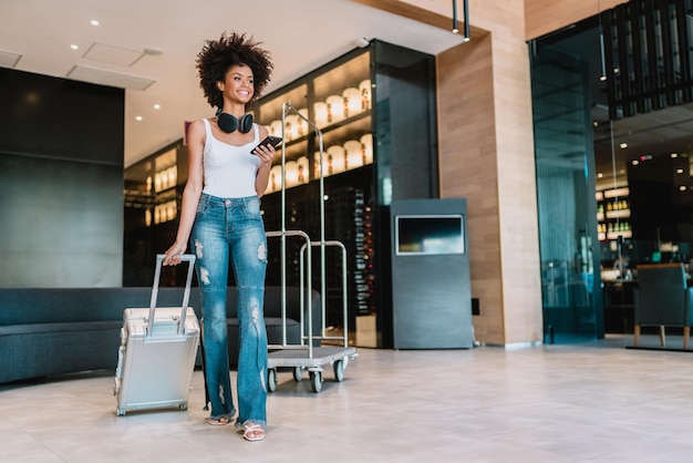 Frau mit Koffer in der Lobby Einchecken im Hotel