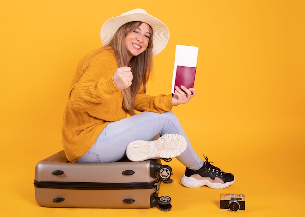 Frau mit Koffer und Hutpass, gelber Raum