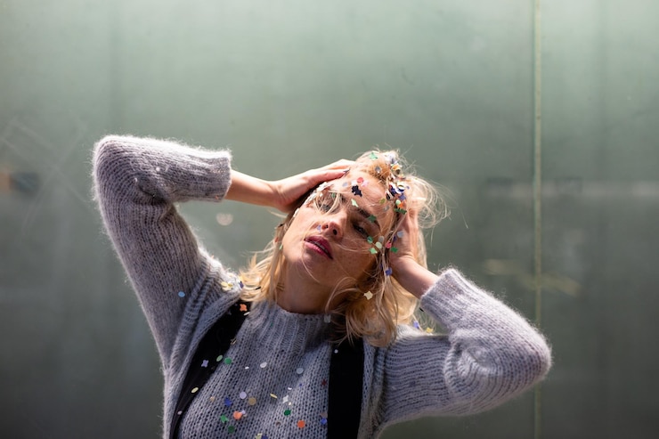 Foto frau mit konfetti in den haaren gegen das fenster