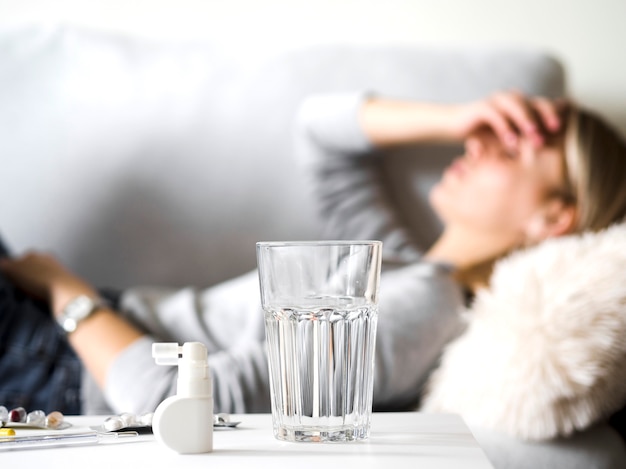 Frau mit Kopfschmerzen auf der Couch