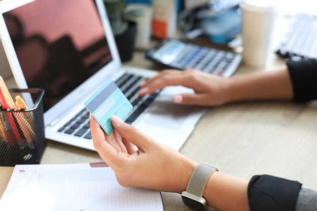 Frau mit Kreditkarte auf Laptop für Online-Shopping-Konzept.