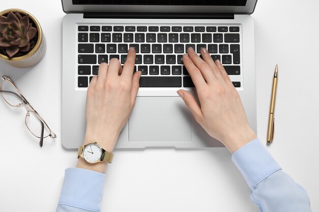 Frau mit Laptop am weißen Tisch