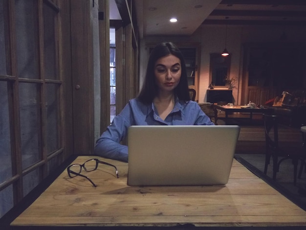Frau mit Laptop arbeitet am Tisch
