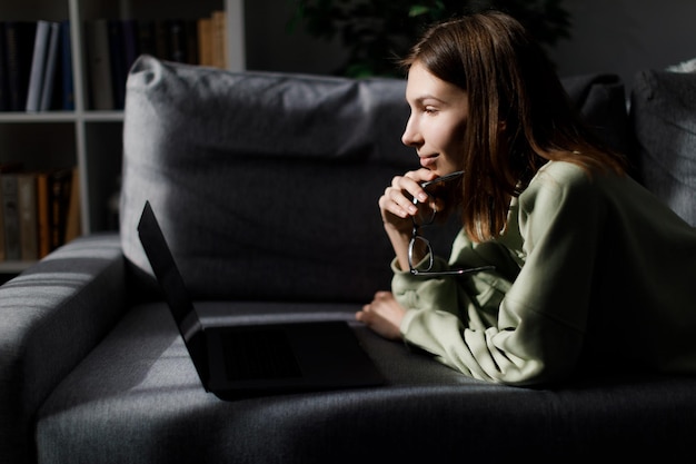 Frau mit Laptop auf Couch