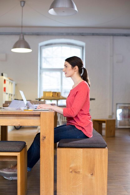 Frau mit Laptop auf dem Tisch im Büro