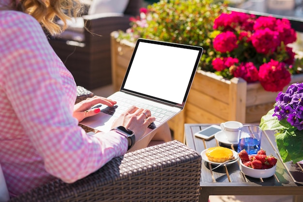 Frau mit Laptop-Computer im Café im Freien