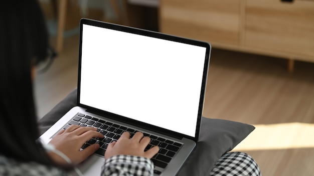 Frau mit Laptop-Computer und auf Sofa sitzend