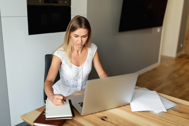 Frau mit Laptop, der zu Hause Büro arbeitet