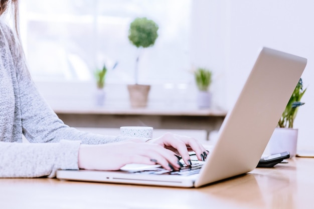 Frau mit Laptop zu Hause auf dem Tisch