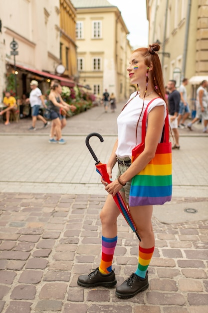 Frau mit lgbt Regenbogen auf ihrem Gesicht, das auf der Straße aufwirft