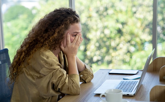 Frau mit lockigem Haar, die zu Hause arbeitet