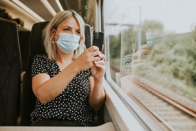 Frau mit Maske fotografiert die Landschaft