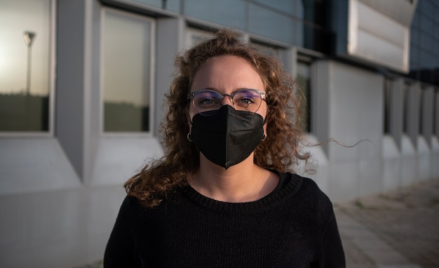 Foto frau mit maske in der umgebung eines bürogebäudes