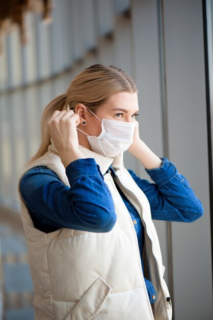 Frau mit medizinischer Gesichtsmaske im Flughafen