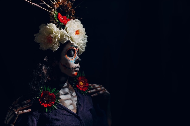 Frau mit mexikanischem Schädel Halloween Make-up auf ihrem Gesicht Tag der Toten und Halloween