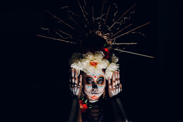 Frau mit mexikanischem Totenkopf-Halloween-Make-up auf ihrem Gesicht Tag der Toten und Halloween