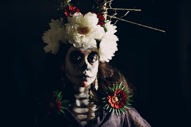 Frau mit mexikanischem Totenkopf-Halloween-Make-up auf ihrem Gesicht Tag der Toten und Halloween