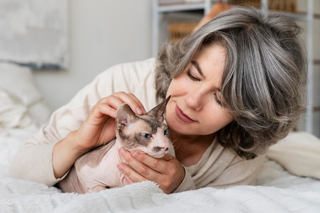 Frau mit mittlerem Schuss, die Katze streichelt