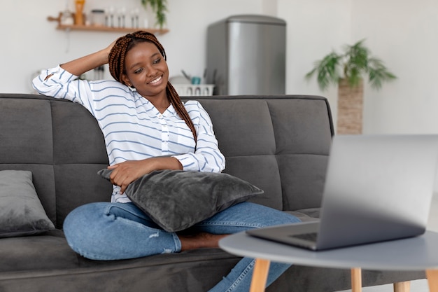 Frau mit mittlerer Aufnahme, die auf der Couch sitzt