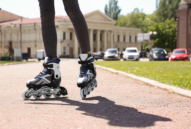 Foto frau mit modernen inline-rollschuhen im stadtpark in der nähe